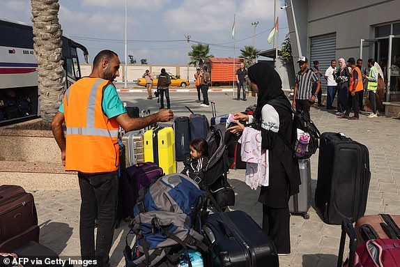 Civilians leaving Gaza wait to board a bus as dual national Palestinians and foreigners prepare to cross the Rafah border point with Egypt, in the southern Gaza Strip, on November 2, 2023. Egypt will help evacuate "about 7,000" foreigners and dual nationals from the war-ravaged Gaza Strip, the foreign ministry said, with officials saying some 400 people were expected to cross on November 2. (Photo by Mohammed ABED / AFP) (Photo by MOHAMMED ABED/AFP via Getty Images)