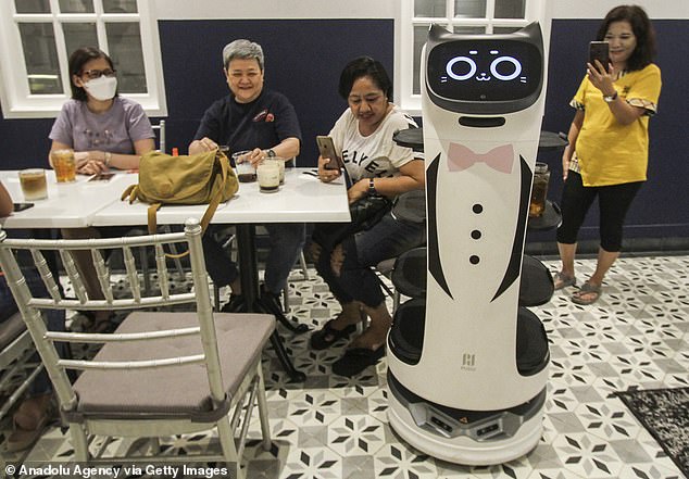 Futuristic: A robot waiter is pictured serving customers at a coffee shop in Jakarta, Indonesia