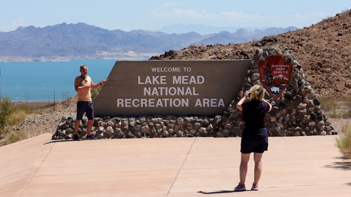 Touristen posieren für Fotos an einem Schild zum Lake Mead National Recreation Area