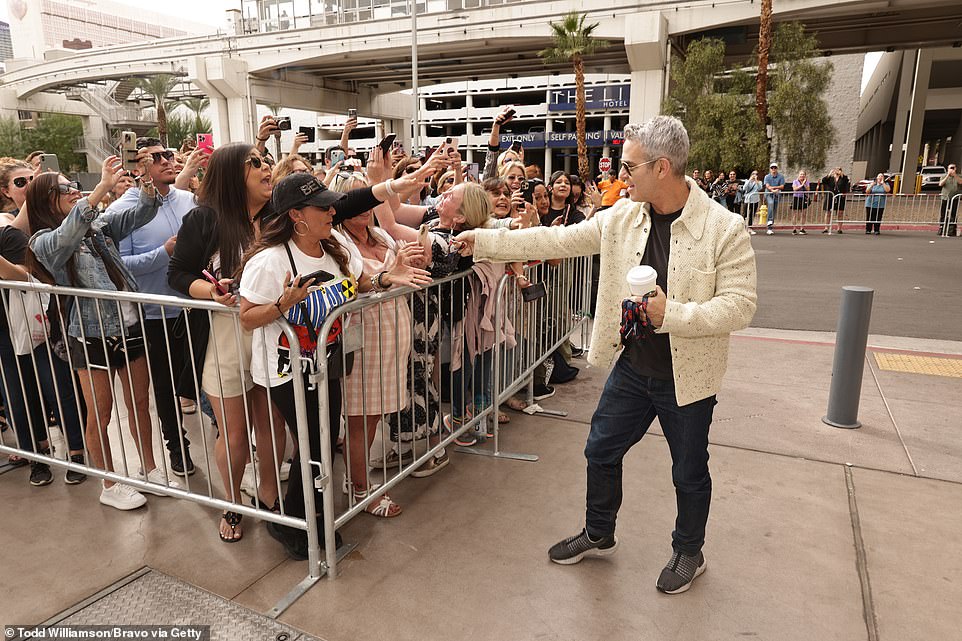 Interacting: He teamed the look with back aviators and was pictured happily interacting with fans outside the venue
