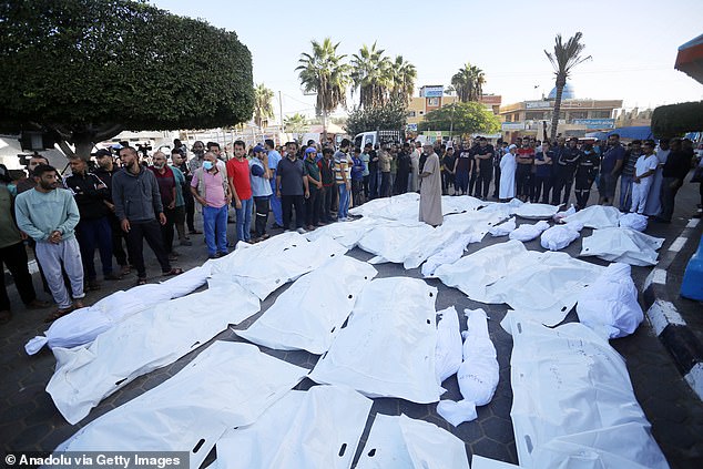 Relatives of Palestinians who died in the Israeli airstrikes gather around the bodies taken from the morgue of Al-Aqsa Martyrs Hospital ahead of the funeral ceremony in Deir Al-Balah, Gaza on November 06, 2023