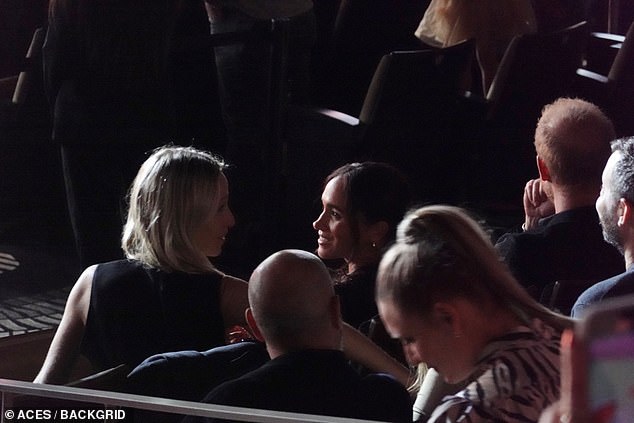Meghan exchanged friendly words with Misha while Harry appeared deep in thought as they sat down