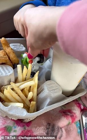 In the video, she films one of her daughters eating from a drinks container, with the tray neatly stacked with fries, chicken nuggets, slices of apple and a milkshake