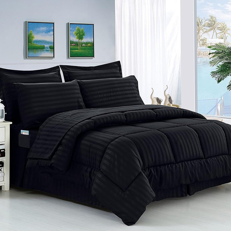Elegantes Komfort-Bettdeckenset: Ein Bett mit schwarzer Bettwäsche in einem weißen, malerischen Zimmer.