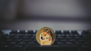Eine goldene Dogecoin-Münze auf der Tastatur, Meme-Münzen zum Verkauf