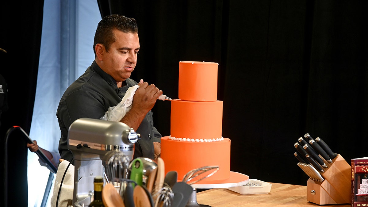 Buddy Valastro dekoriert während einer Kochvorführung einen Orangenkuchen