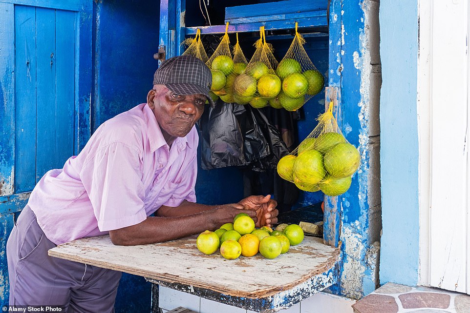 Auf dem Markt: In Guyana leben nur rund 800.000 Menschen, die meisten davon in der Hauptstadt Georgetown.  Oben: ein Einheimischer, der in der Stadt Zitrusfrüchte verkauft