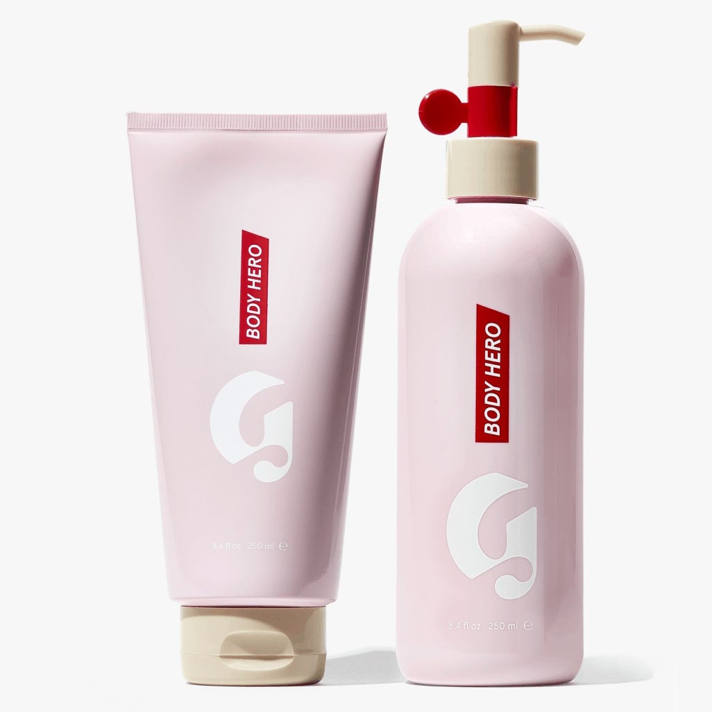 Glossier Body Hero Duo Set Pumpflasche und Quetschflasche in Rosa auf grauem Hintergrund