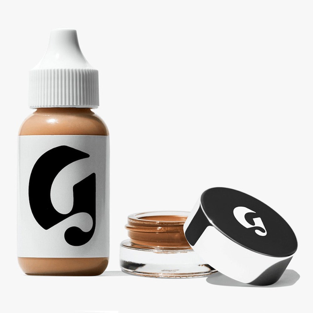Glossier Perfecting Skin Tint + Stretch Balm Concealer Duo Flasche und Glas mit silberner Kappe auf weißem Hintergrund