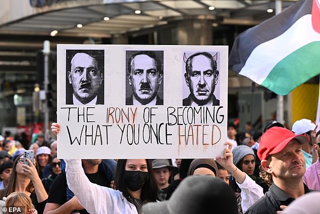 Ein Demonstrant in Brisbane hält ein Schild in der Hand, auf dem Israels Ministerpräsident Benjamin Netanjahu mit Adolf Hitler verglichen wird