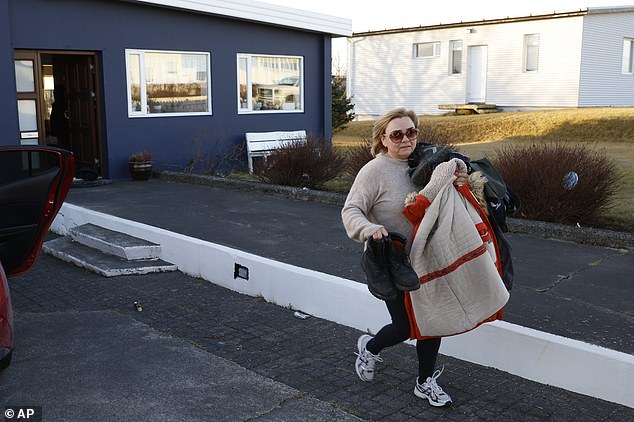 Eine Bewohnerin der isländischen Stadt Grindavik holt einige ihrer Habseligkeiten aus ihrem Haus, nachdem ihr zur Evakuierung befohlen wurde