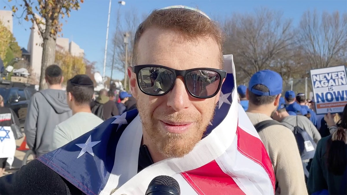 Mann trägt amerikanische Flagge über den Schultern beim Marsch für Israel auf der National Mall