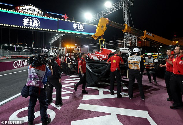 Der Ferrari von Carlos Sainz wird von einem Kran von der Strecke entfernt, nachdem er über die Abdeckung gefahren ist