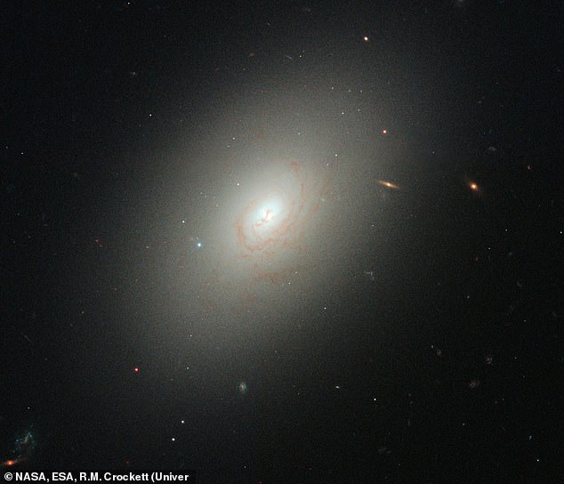 12P/Pons-Brooks wurde plötzlich mehr als 100-fach heller und leuchtete so hell wie die elliptische Galaxie (im Bild), 600 Millionen Lichtjahre von der Erde entfernt