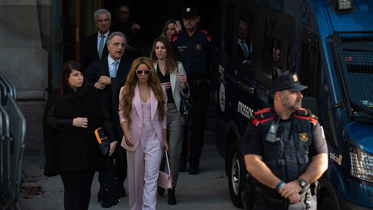 Shakira geht mit einer Gruppe von Menschen hinter ihr her, als sie den Gerichtssaal verlässt