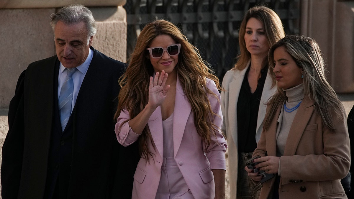 Shakira im rosa Anzug winkt den Fans vor dem Gerichtsgebäude von Barcelona zu