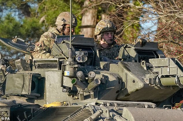 The Prince of Wales, Colonel-in-Chief, 1st Battalion Mercian Regiment (right) rides in a Warrior Armoured Fighting Vehicle as he takes part in an attack exercise during a visit to the regiment