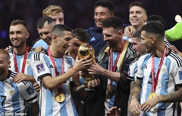 Di Maria steht neben dem argentinischen Kapitän Lionel Messi, als er den WM-Pokal in die Höhe streckt