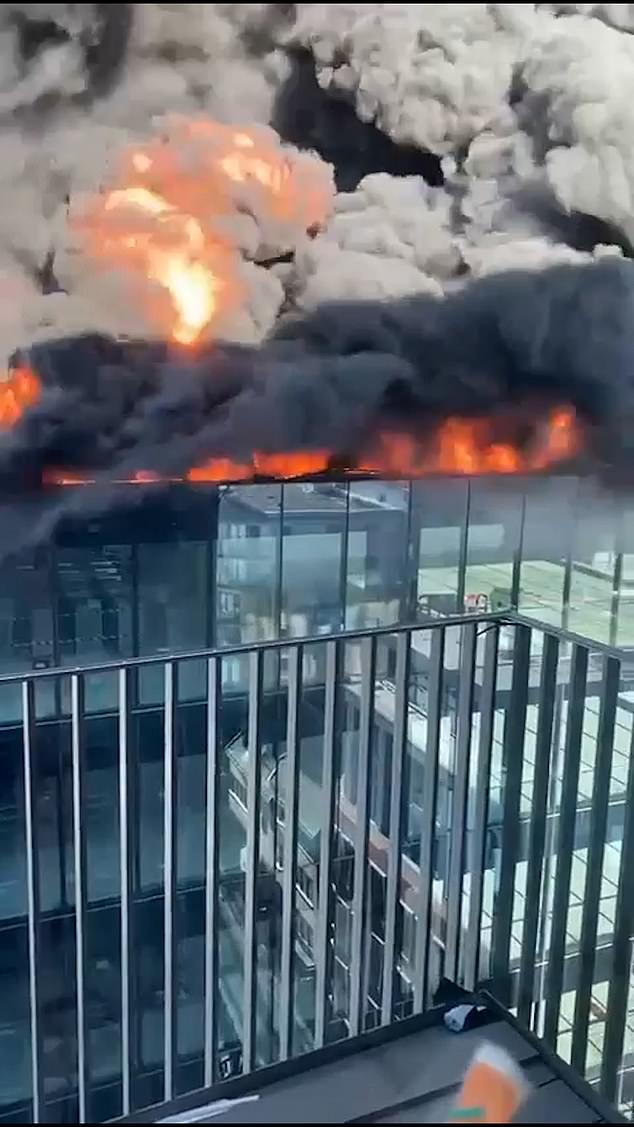 The builder can be seen stranded alone on top of the One Station Hill office development close to Reading Station, as his feet become engulfed in flames