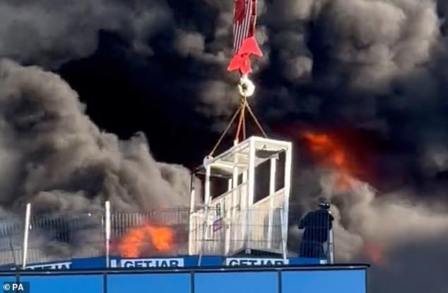 The dramatic three-minute rescue undoubtedly saved the builder's life as all around him blazing cladding caused massive clouds of toxic smoke