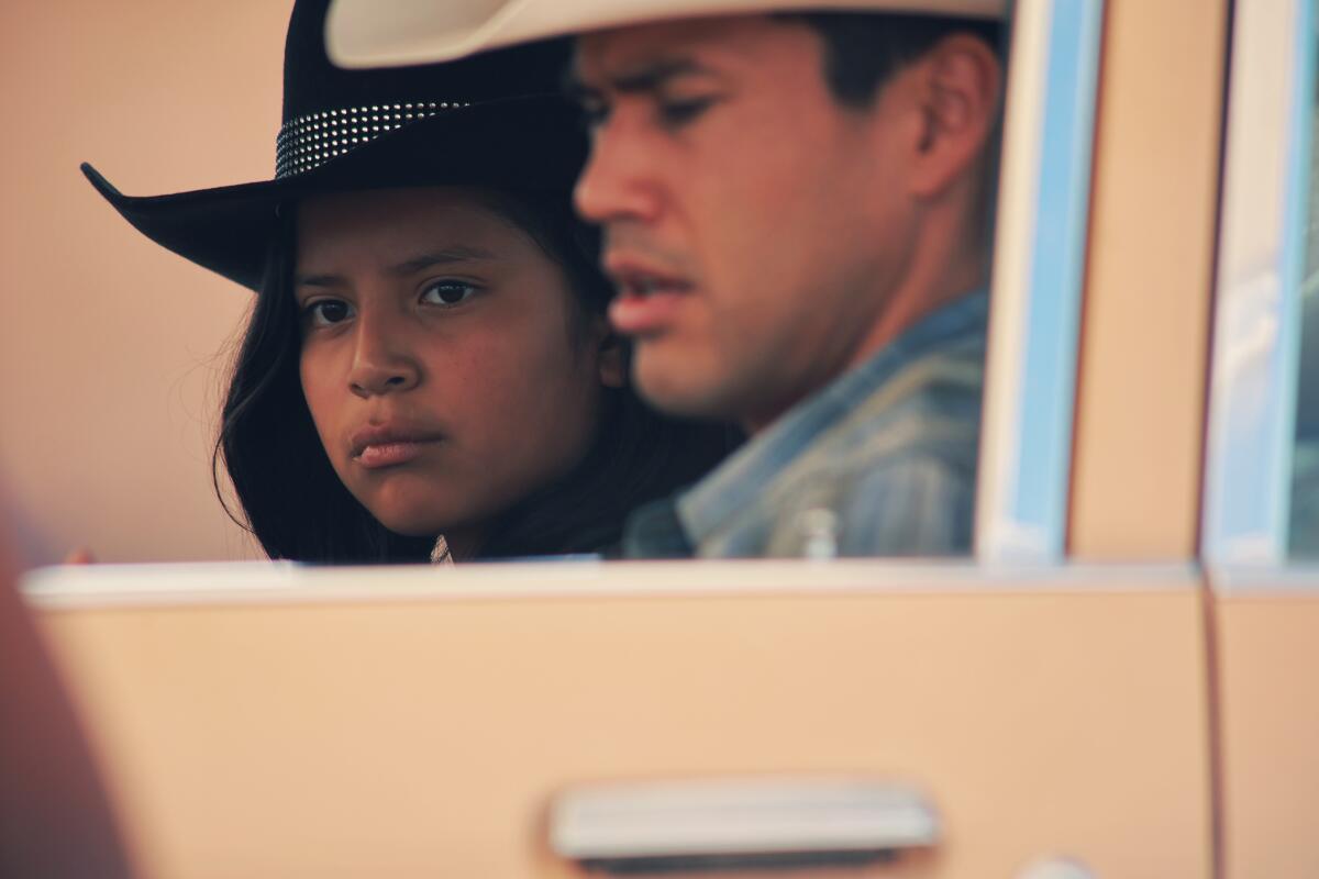 Zwei Personen mit Cowboyhüten in einem Auto.