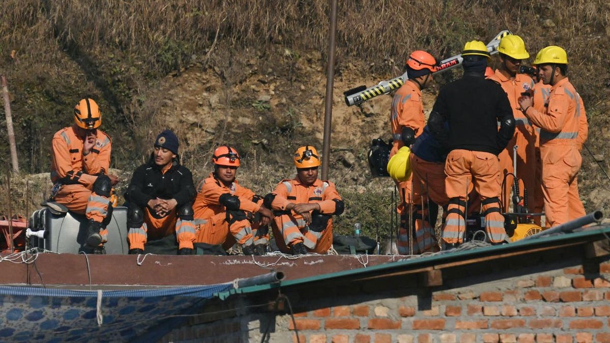 Rettungskräfte brechen zusammen, während sie sich auf vertikale Bohrungen vorbereiten, um eingeschlossene Arbeiter im indischen Tunnel zu erreichen