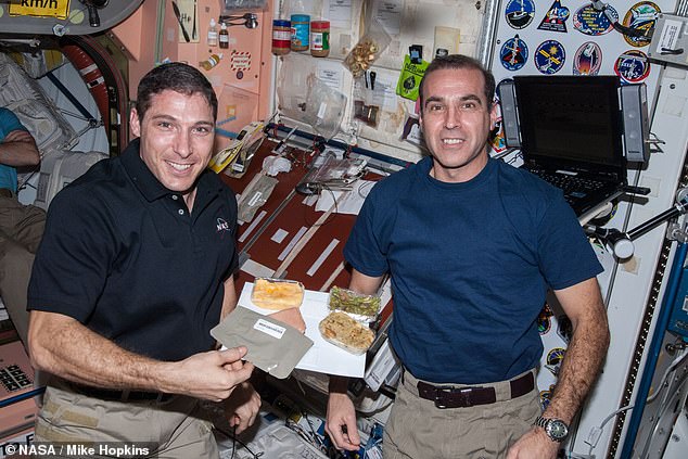 Im Laufe von 50 Jahren hat sich das Thanksgiving-Dinner auf der ISS weiterentwickelt.  Hier präsentieren Michael Hopkins (links) und Rick Mastracchio (rechts) ihr Abendessen 2013 mit geräuchertem Truthahn, grünen Bohnen und Füllung