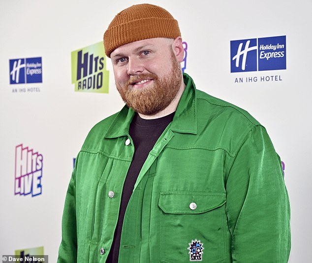 Gemütlich: Tom Walker, 31, machte anderswo eine lässige Figur in einer grünen Jeansjacke, einem schwarzen T-Shirt und einer orangefarbenen Mütze