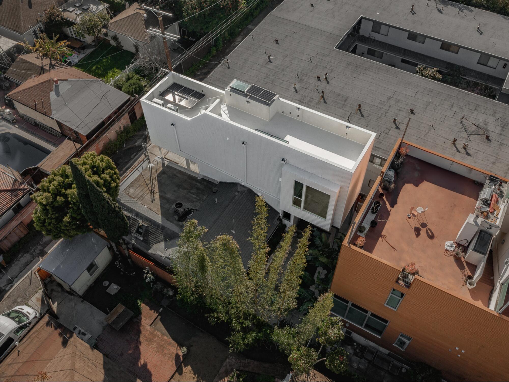 Eine Drohnenaufnahme zeigt eine zweistöckige ADU, die zwischen einem Bungalow und einer modernen Doppelhaushälfte eingefügt ist