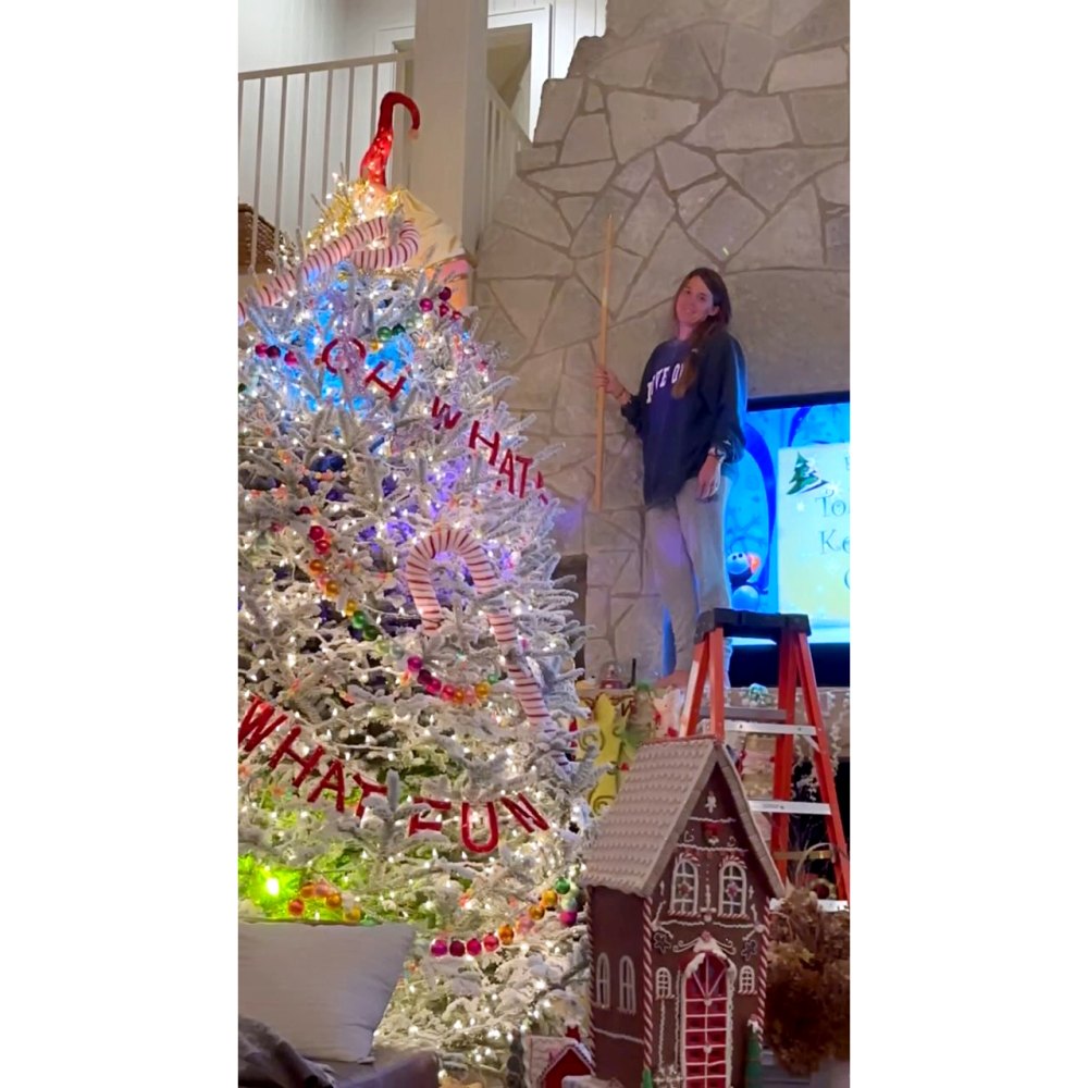 Thomas Rhett kann nicht aufhören, über seine Frau Lauren zu lachen, die auf die Leiter klettert, um den hohen Weihnachtsbaum zu schmücken 
