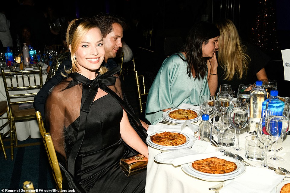 Yum! Robbie was seen sitting down next to her spouse