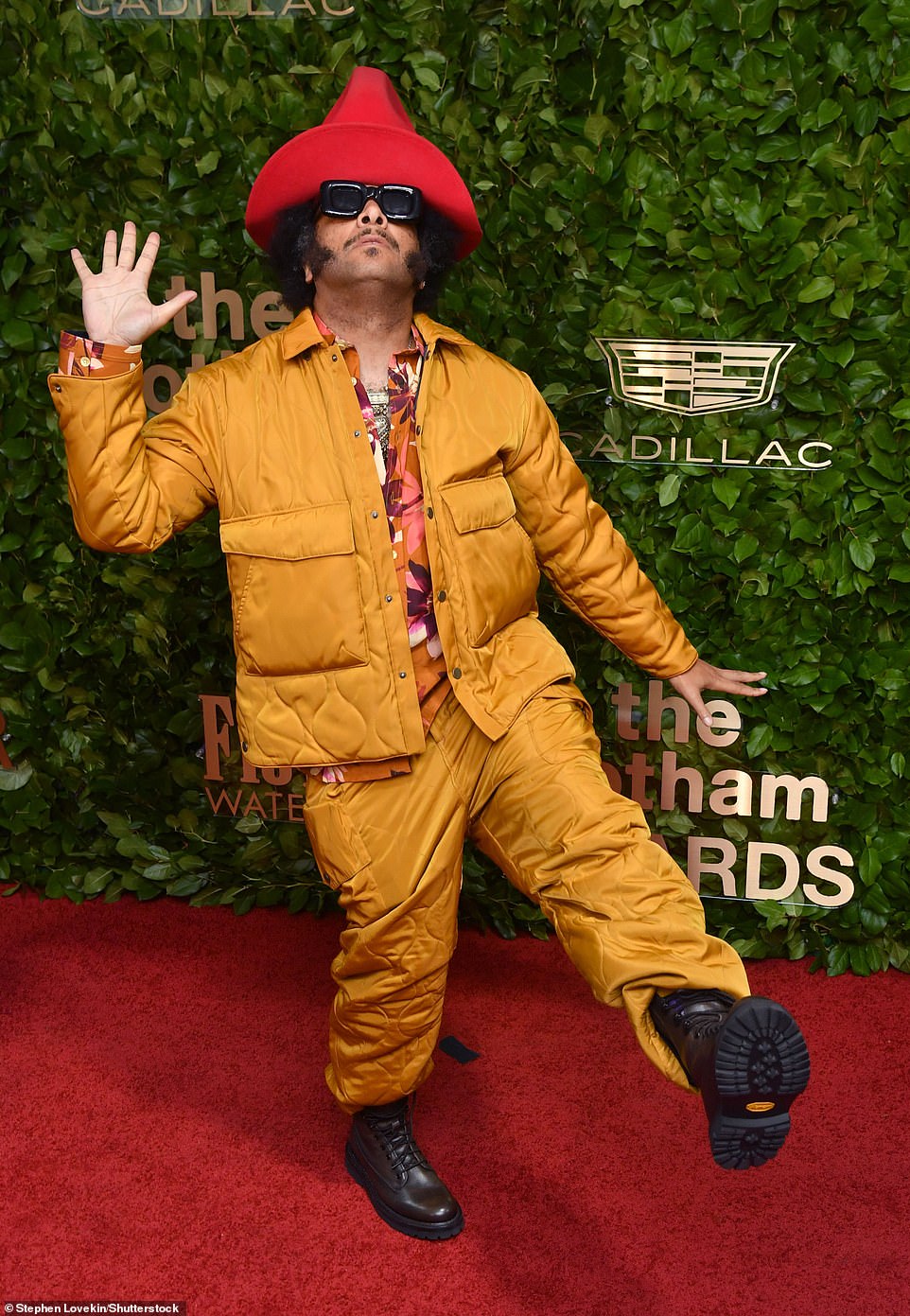 Funny: Film director Boots Riley showed off his eccentric fashion sense  in a yellow padded jacket and pants, which he paired with a floral shirt and black boots