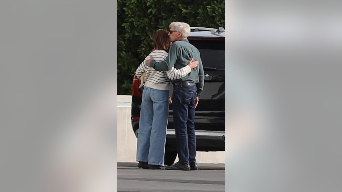 Harrison Ford und Calista Flockhart umarmen sich am Flughafen