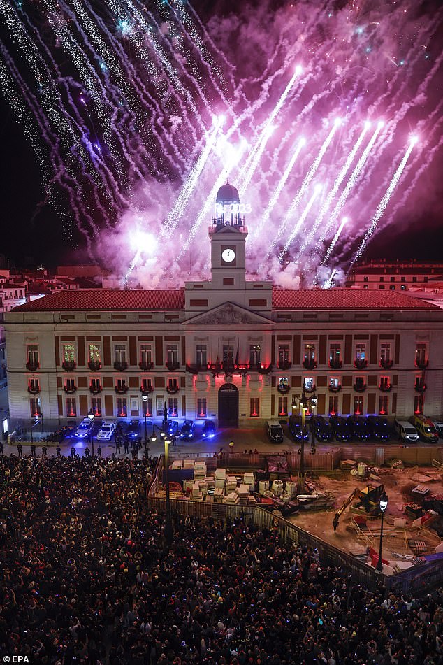 Hunderte Menschen versammeln sich um Mitternacht während des traditionellen Silvesterglockenspiels am letzten Tag des Jahres 2022 in Madrid, Spanien