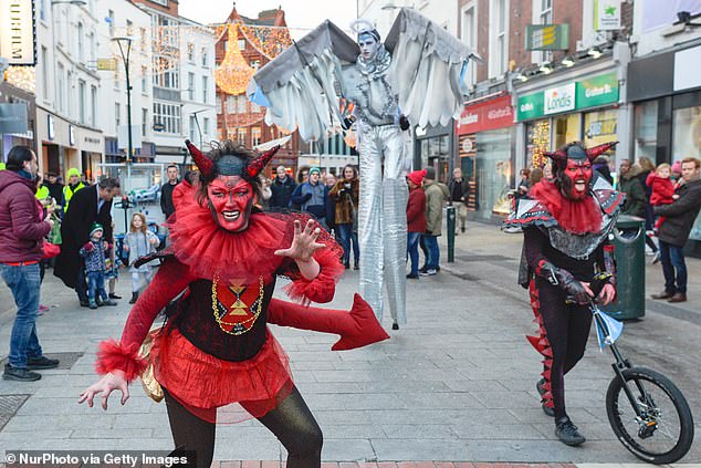 Als Engel und Teufel verkleidete Mitglieder des Dublin Circus Project treten am Neujahrstag in der Grafton Street in Dublin auf