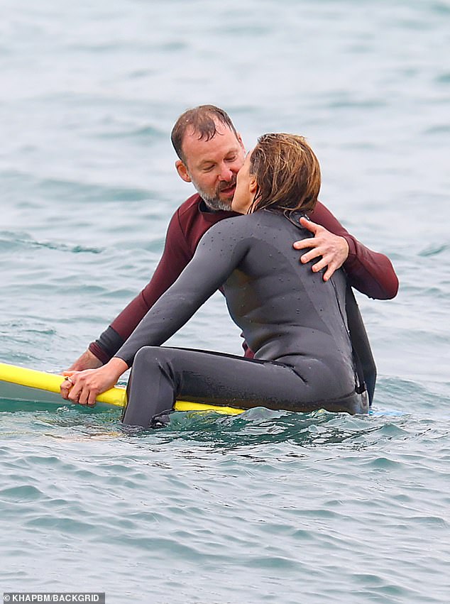 Fotos zeigten, wie das Paar in den Wellen Küsse austauschte, während sie mit ihren Surfbrettern herumtrieben, beide in Neoprenanzügen gekleidet