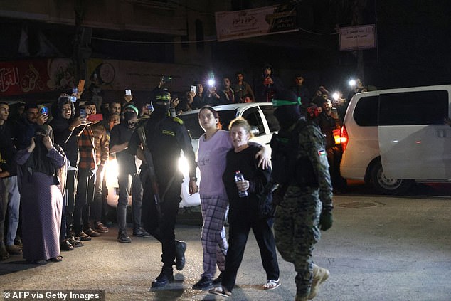 Hamas-Kämpfer begleiten neu freigelassene Geiseln, bevor sie sie dem Roten Kreuz in Rafah übergeben