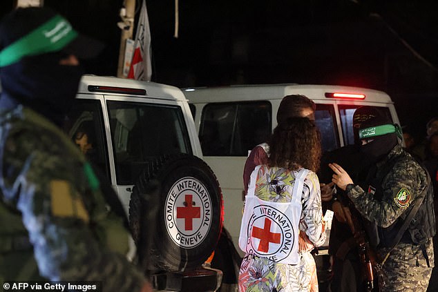Hamas- und Islamische Dschihad-Kämpfer sprechen während der Freilassung von Geiseln in Rafah mit Mitgliedern des Roten Kreuzes