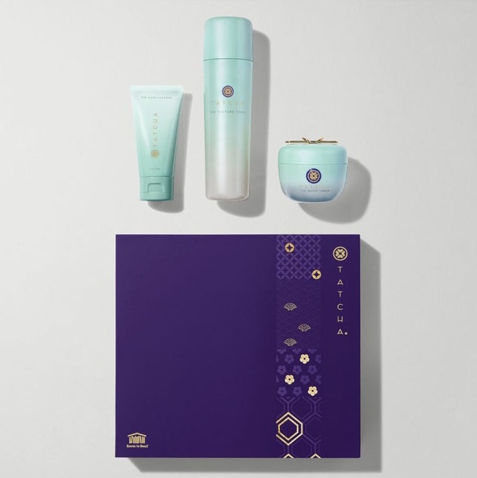 Tatcha Clarified & Balanced Trio, drei Minz-Hautpflegeflaschen und lila Box auf grauem Hintergrund