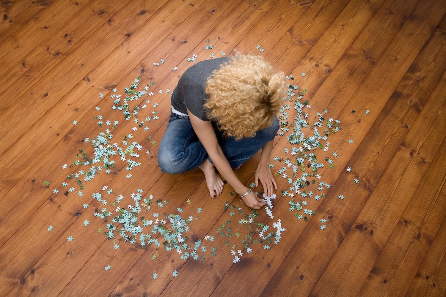 Frau macht Puzzle auf dem Boden