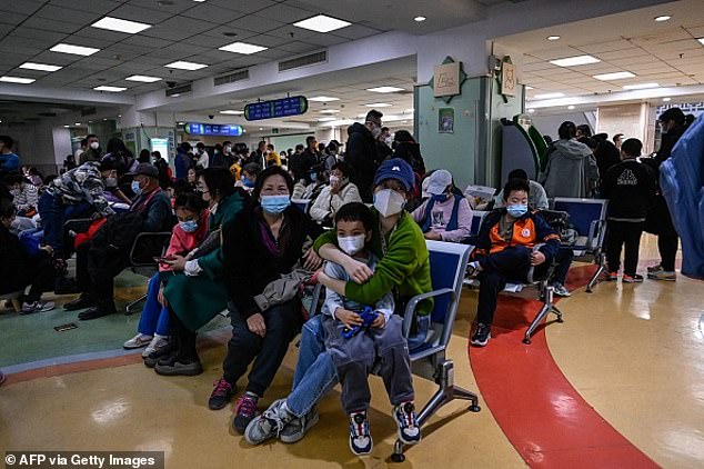 Kinder und ihre Eltern warten in der Ambulanz eines Kinderkrankenhauses in Peking, während die Krankenhäuser der Stadt mit Fällen eines neuen Virus überschwemmt werden.  Es besteht die Befürchtung, dass die Krankheit auch in die USA gelangt sein könnte