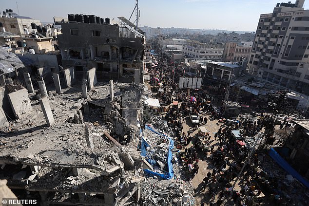 Palestinians shop in an open-air market among the ruins of houses and buildings destroyed in Israeli strikes during the conflict, amid a temporary truce between Hamas and Israel, in Nuseirat refugee camp in the central Gaza Strip on Thursday
