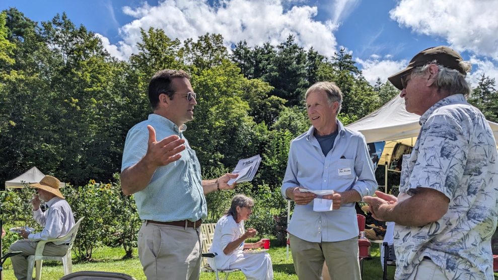 Seth Berry, ein Autor des Pine Tree Power-Wahlvorschlags, der die staatseigenen Versorgungsunternehmen durch ein gemeinnütziges ersetzen würde, unterhält sich im August 2023 bei einem Treffen von Klimaaktivisten in Winslow, Maine, mit Wählern.