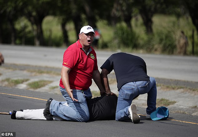 The first man to be shot is seen being treated on the ground by two bystanders