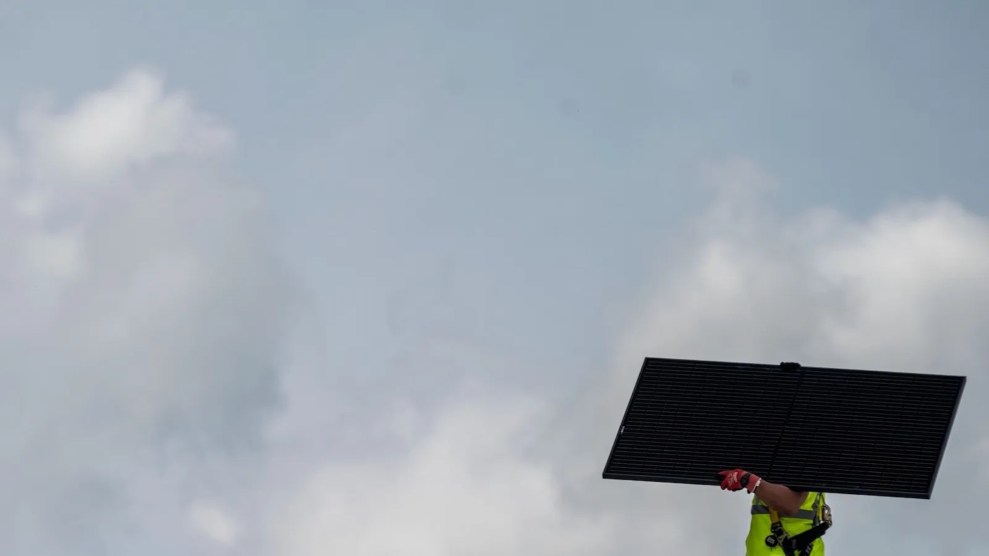 Eine Person, die ein Solarpanel trägt, das ihr Gesicht verdeckt, mit bewölktem Himmel im Hintergrund