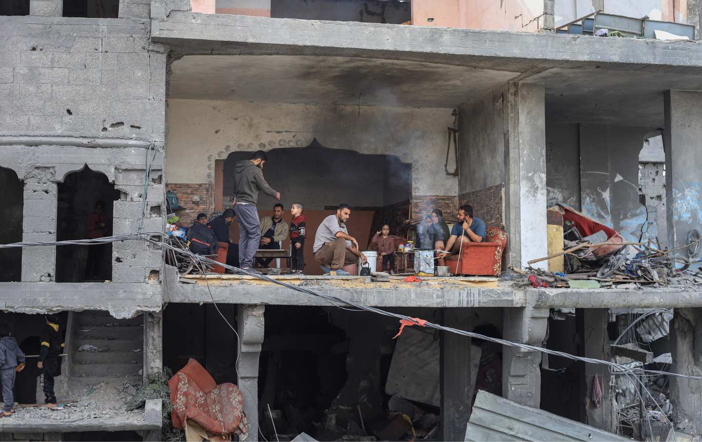 Palästinenser in ihrem zerstörten Haus im Flüchtlingslager in Nuseirat, Gaza, am Samstag, 25. November 2023.