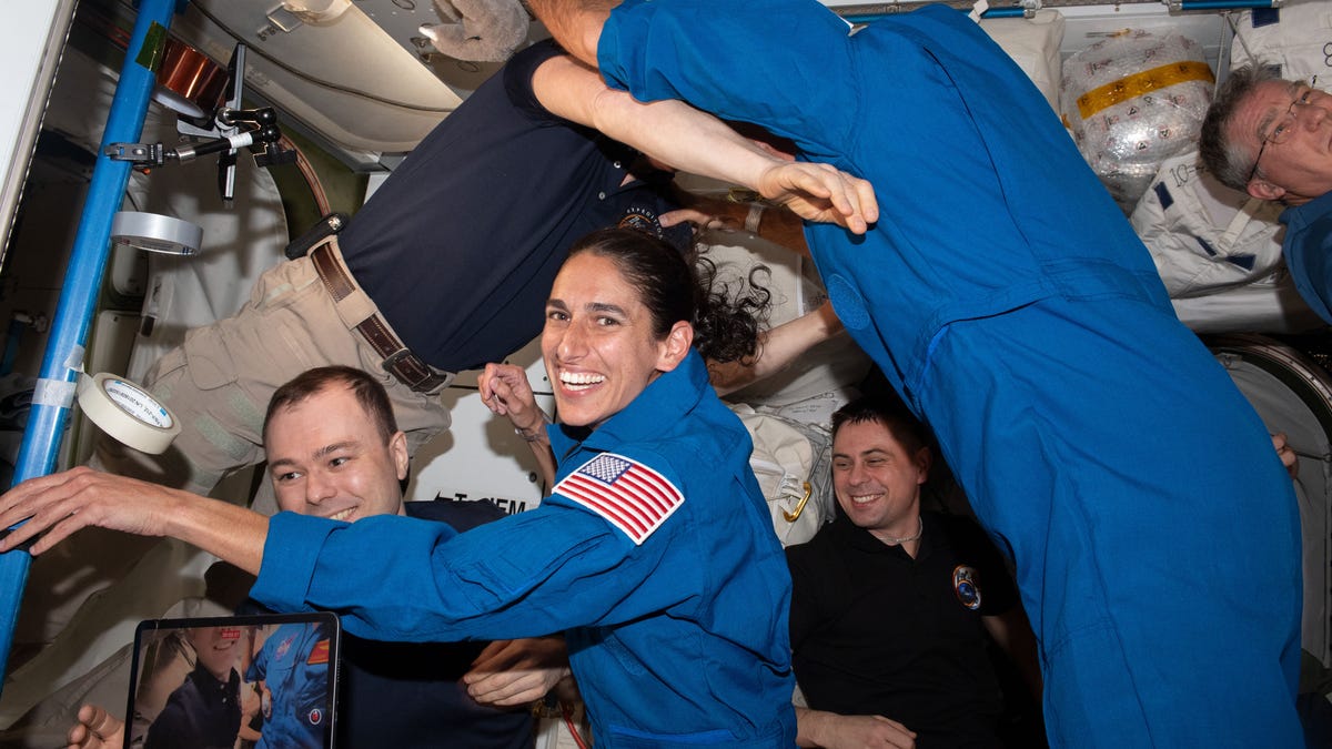 NASA-Astronautin Jasmin Moghbel umgeben von schwebenden Besatzungsmitgliedern an Bord der ISS