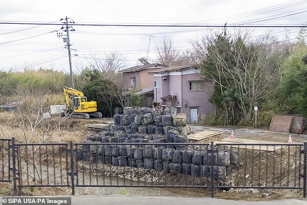 In der Stadt Futaba, die 2011 unter den Folgen der Atomkraftwerkskatastrophe von Fukushima litt, wurden schwarze Plastiktüten mit Schichten kontaminierter Muttererde abgekratzt, um die Strahlung zu entfernen