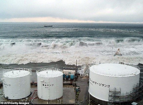 Tsunamiwellen krachen über die Ufermauern in Richtung TEPCOs Kernkraftwerk Fukushima Daiichi in Okuma