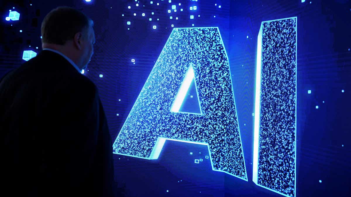 AI in Druckbuchstaben vor blauem Hintergrund